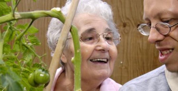 Old lady smiling with a young man with glasses