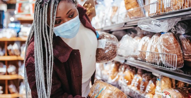 Black woman choosing bread in baking department