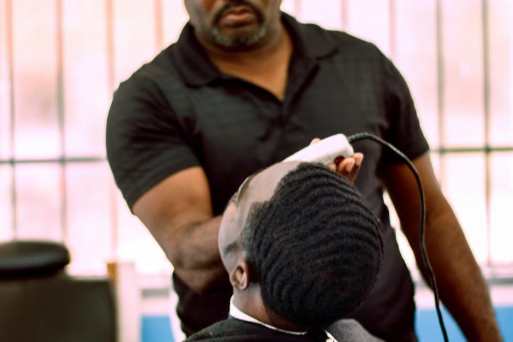 Barber giving a haircut to a person