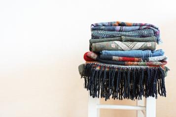 Pile of clothes on white wooden stool